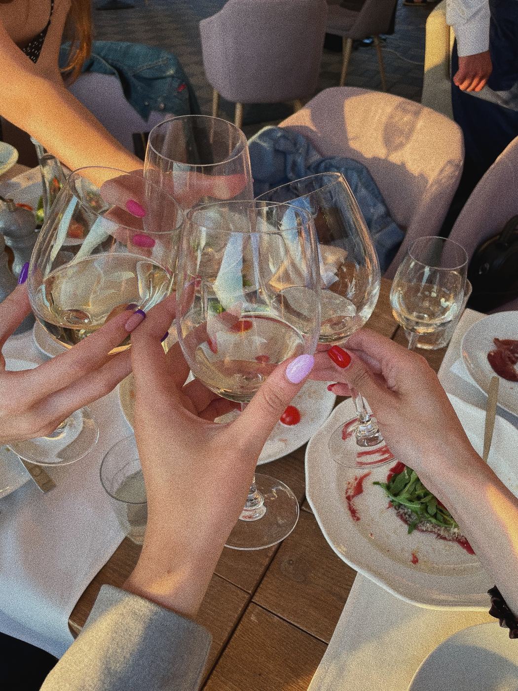Friends clinking wine glasses to celebrate a booked trip